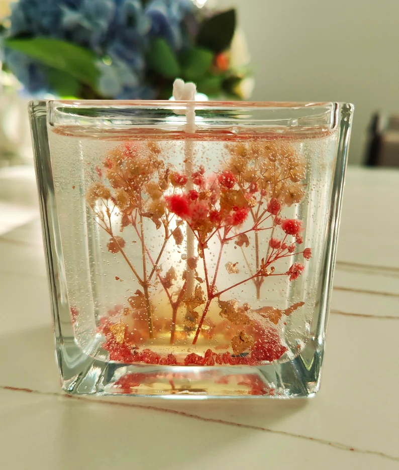 floral-embedded gel candle in clear glass cube