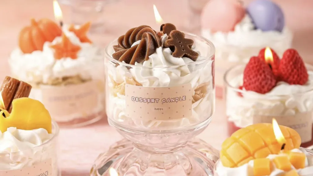 Best Budget Candle Brand Start: Dessert Handmade Candles 2 Dessert style scented candle in a glass cup with whipped cream wax and fruit-shaped toppings, soft pastel aesthetic